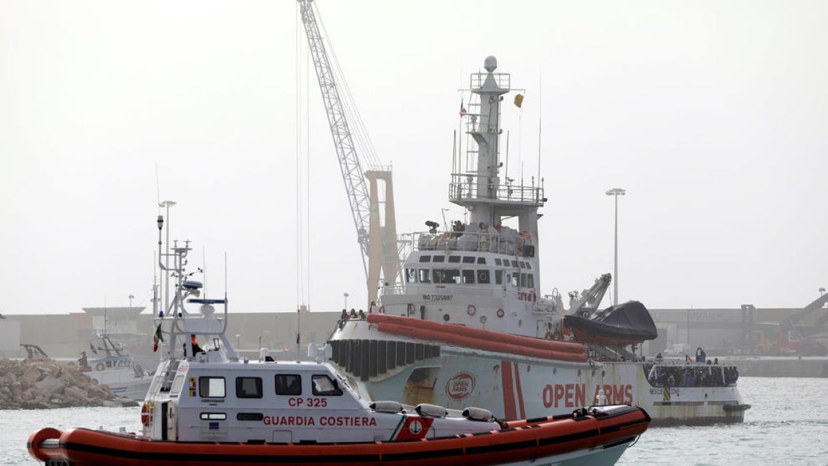 Imagen de los migrantes esperando para desembarcar del barco de la ONG Open Arms en el puerto de Pozzalo.