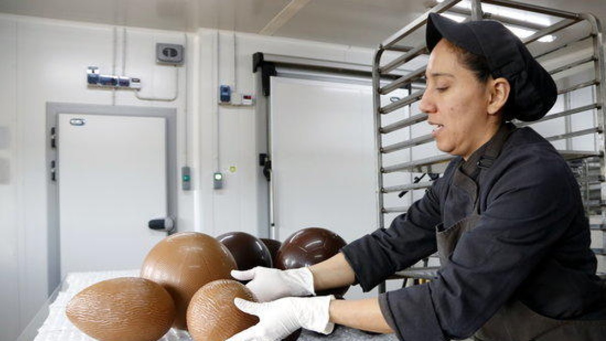 Una de les pastisseres treu els ous de Pasqua de dins dels motlles.