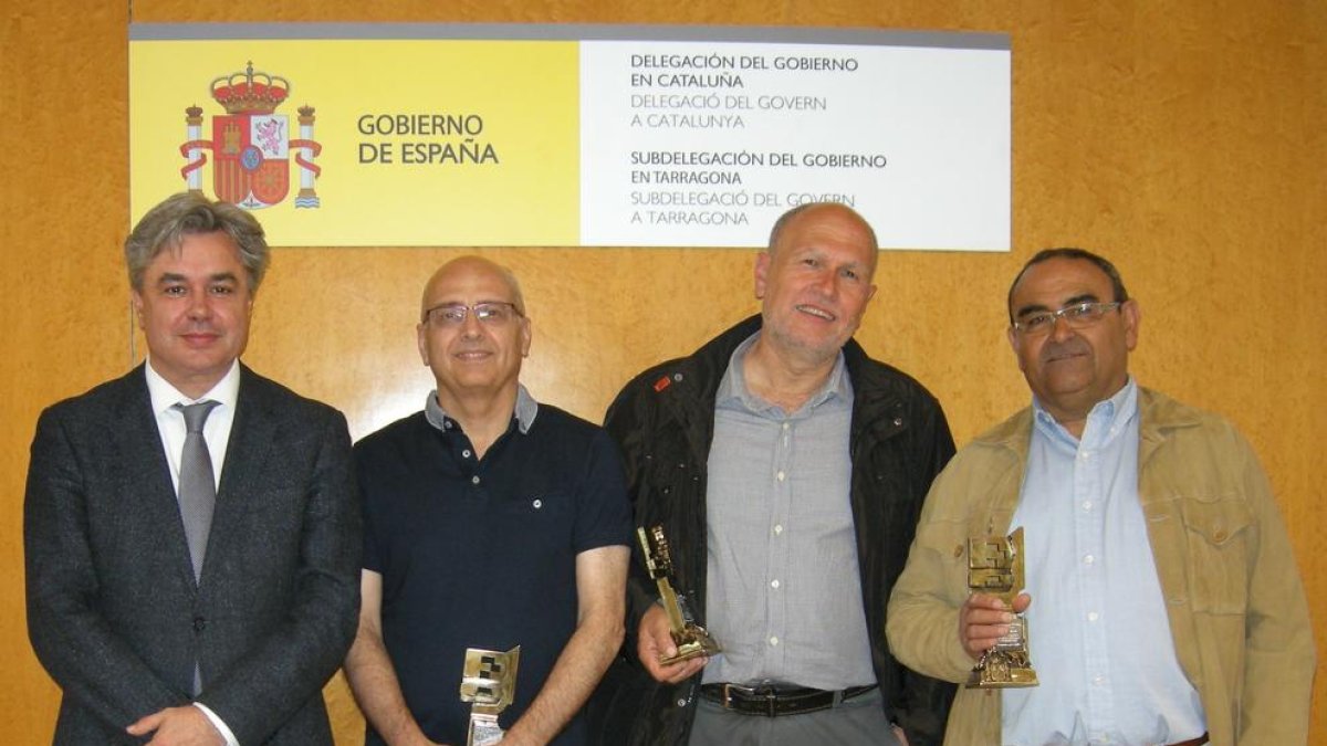 El subdelegat del govern amb els tres funcionaris homenatjats.