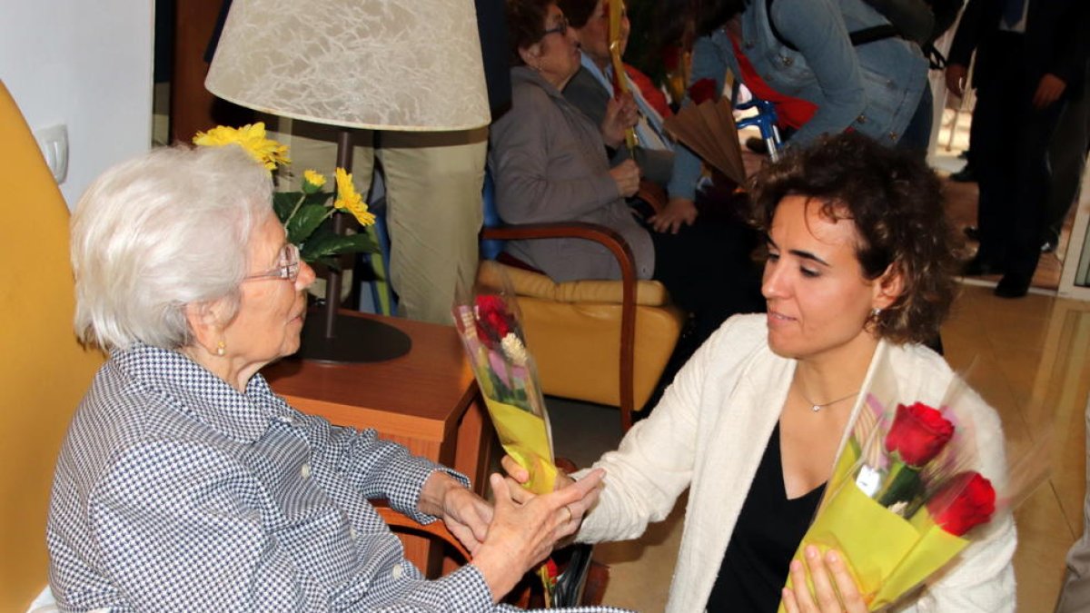 Dolors Montserrat entrega una rosa a una dona.