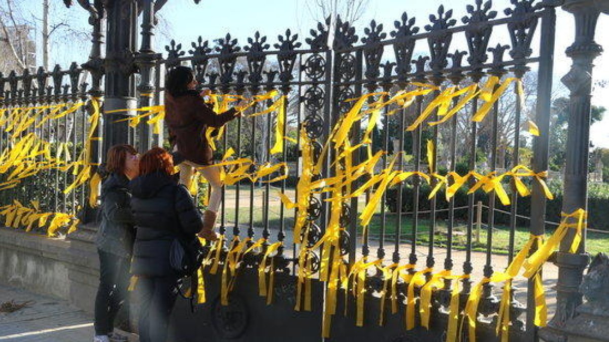 Imagen de gente atando lazos amarillos a la reja del parque de la Ciutadella, donde se produjo la agresión.