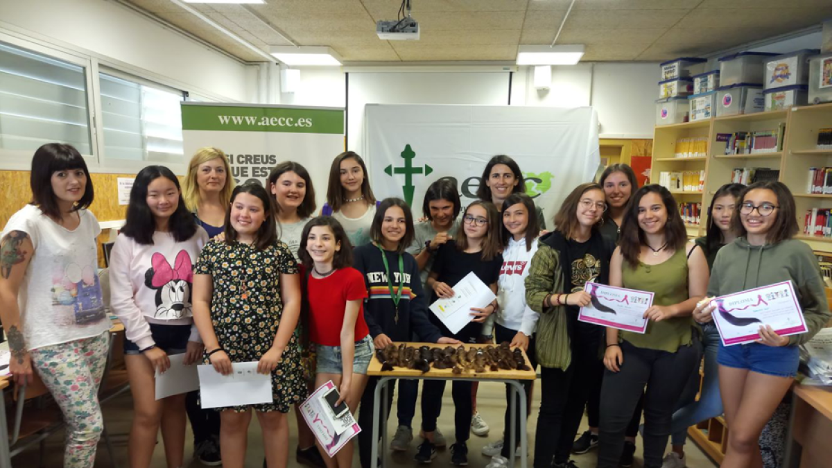 Les noies després de donar el cabell al costat de les perruqueres i la coordinadora de l'AECC a Tarragona.