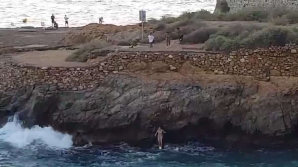 Instant on la primera noia es llença a l'aigua, sota l'atenta mirada dels altres tres menors.