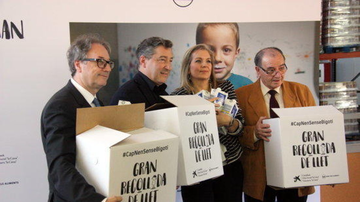 Marc Simón, Joan Roca, Marta Peris y Frederic Gómez Pardo cogiendo las cajas para la recogida de leche durante la presentación de la campaña 'Ningún niño sin bigote'.