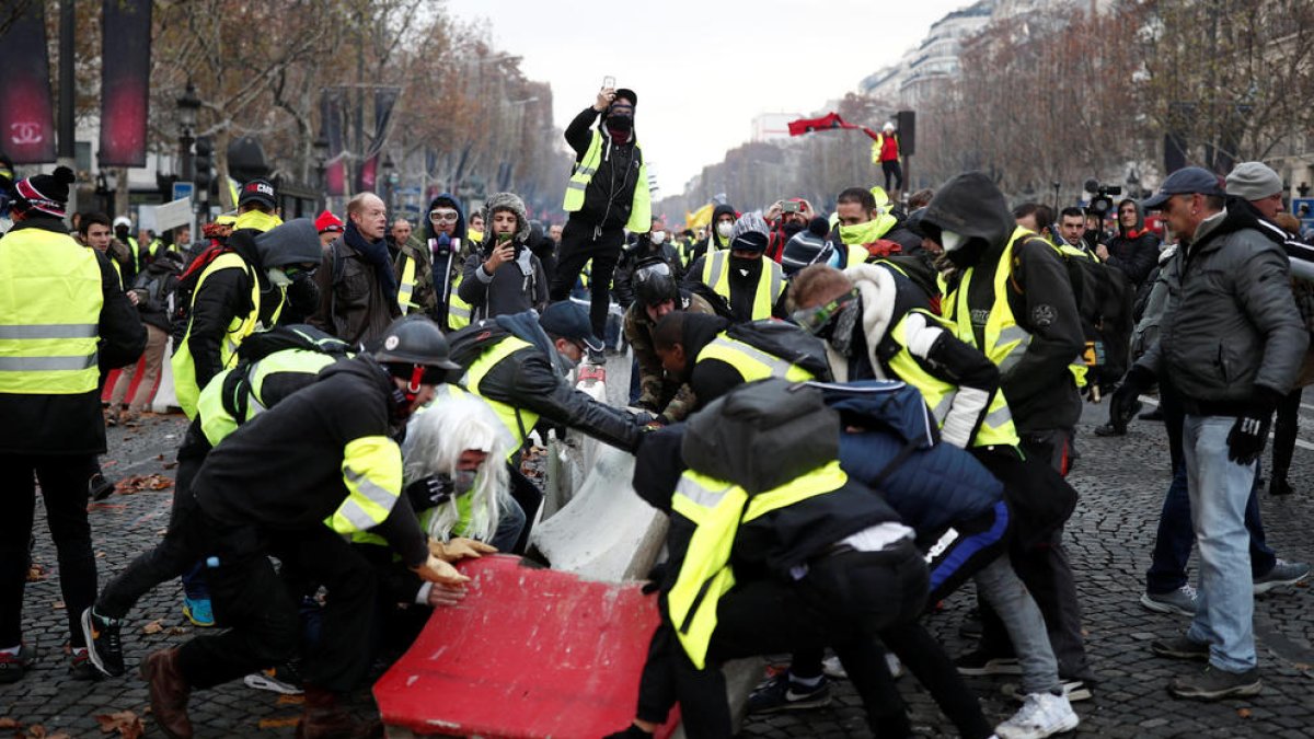 Imatge dp'arxiu de manifestants 'armilles grogues' fent una barricada als carrers de París.