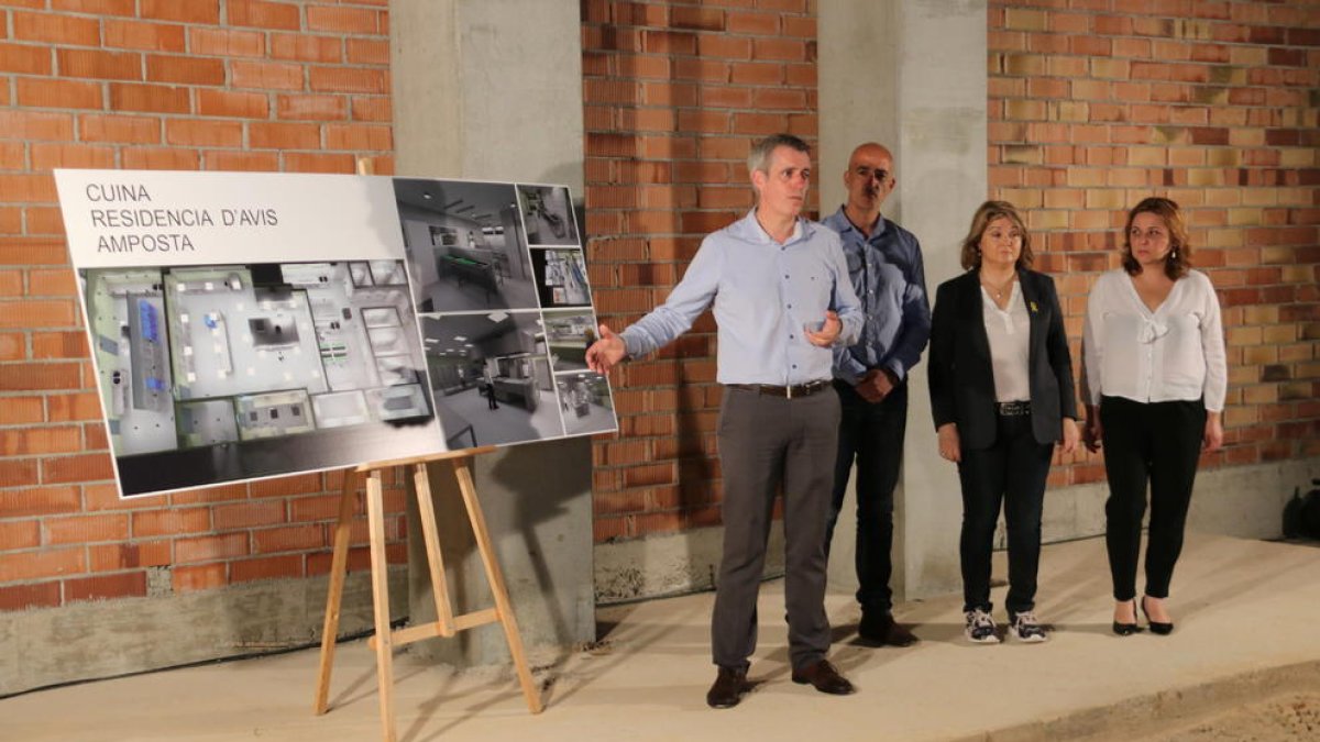 Plano conjunto del alcalde de Amposta, Adam Tomàs, a la izquierda, presentando los detalles del proyecto de la cocina de la residencia de abuelos.