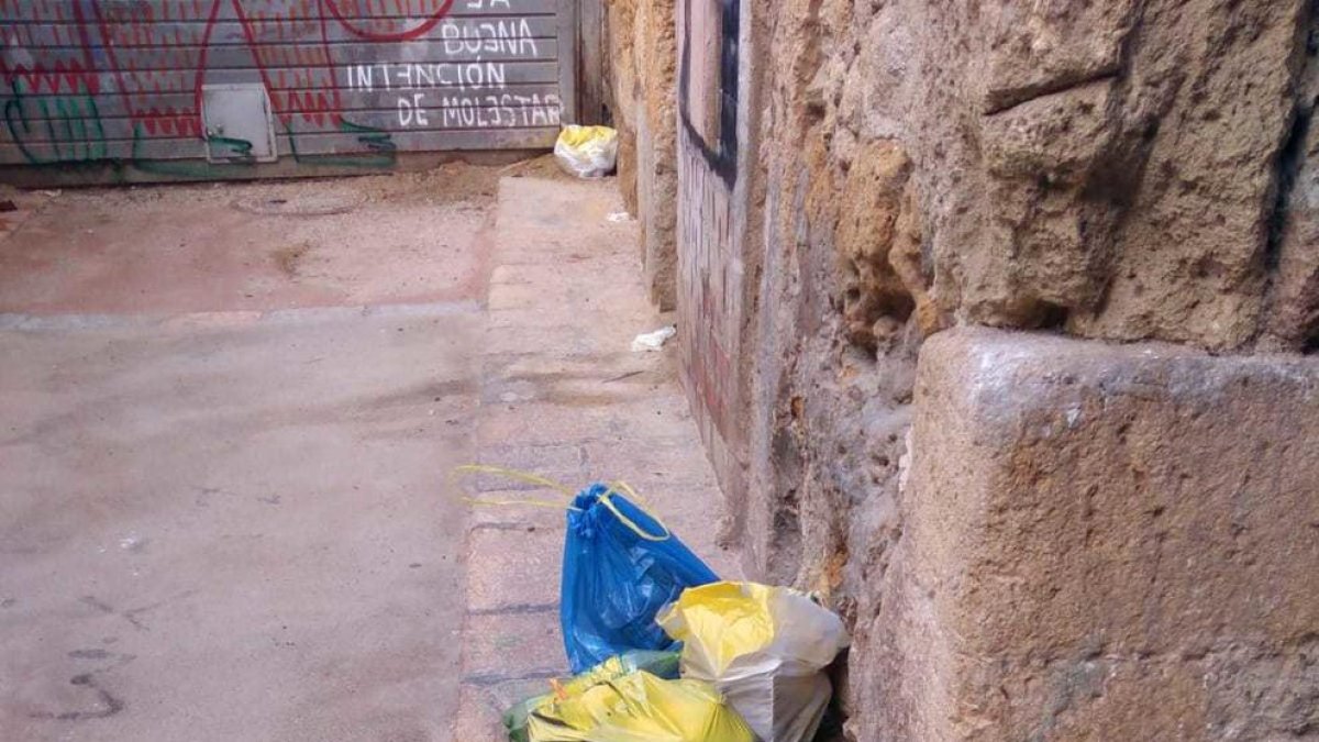 Una bolsa de basura dejada en el suelo pintada de amarillo.