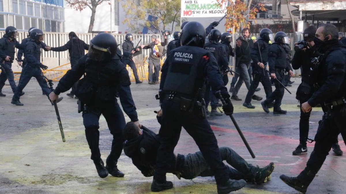Dos agentes de los Mossos, arrastrando a un manifestante antifascista en la plaza U d'Octubre de Gerona.