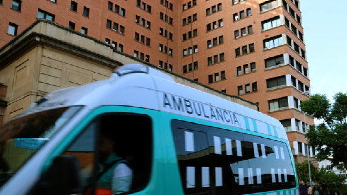 Una ambulància en marxa passa per davant de l'entrada principal de l'Hospital de la Vall d'Hebron de Barcelona.