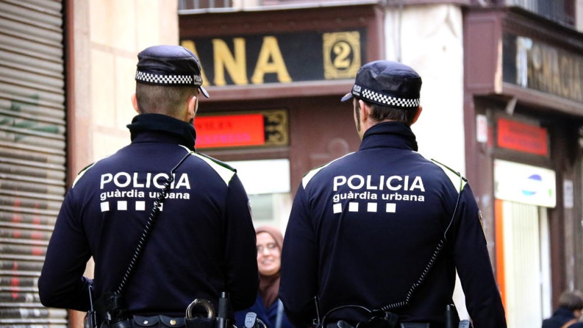 Dos agentes de la Guardia Urbana patrullando para|por Barcelona.