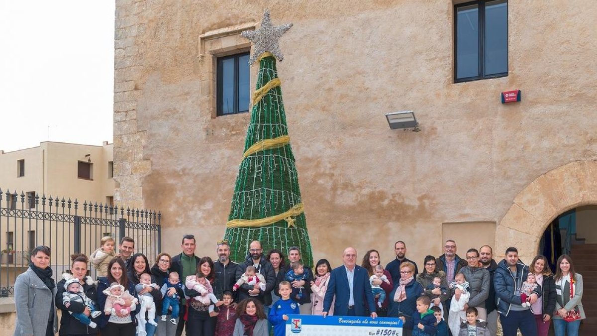 Fotografía de grupo de las familias que han recibido el Xec Nadó en el 2018 junto al alcalde, Roc Muñoz, y varios concejales del consistorio.