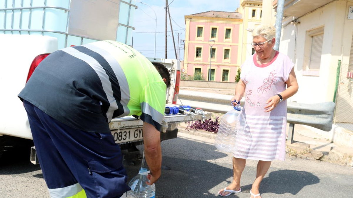 Un operari de la Brigada Municipal de Móra la Nova omple les garrafes d'una veïna.