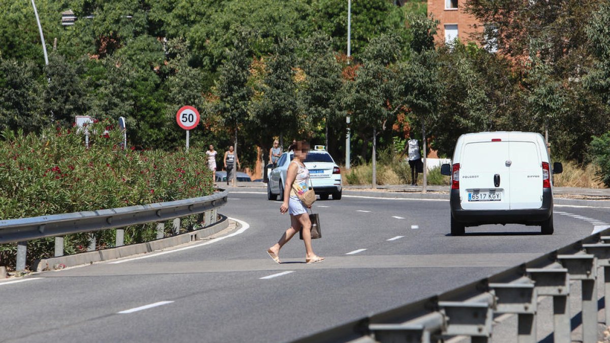 Algunos peatones pasan por Bellissens esquivando los coches.