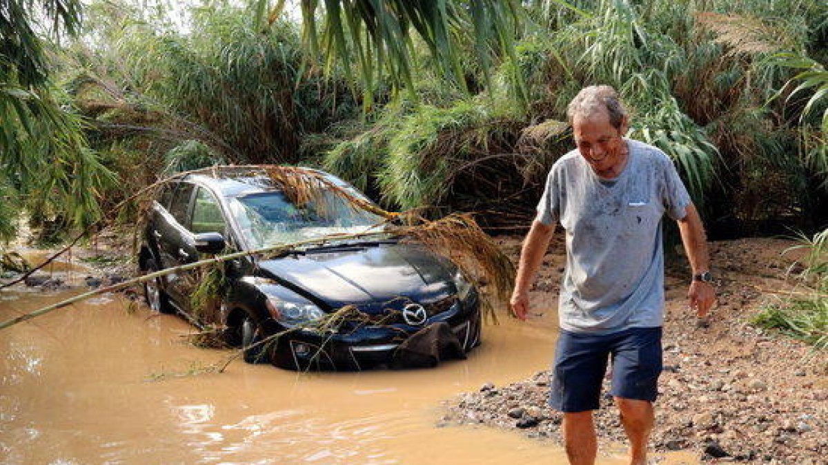 El Celestino, caminant descalç per la riera de Maspujols amb el seu vehicle embarranncat al fons, el qual va haver d'abandonar per l'augment del cabal.