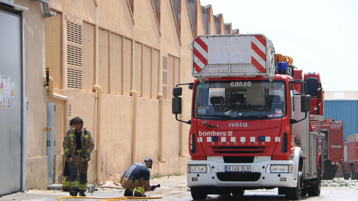 Pla tancat dels efectius dels bombers treballant per extingir l'incendi en una nau del polígon Entrevies de Tarragona. Imatge del 7 de juliol del 2019 (Horitzontal).