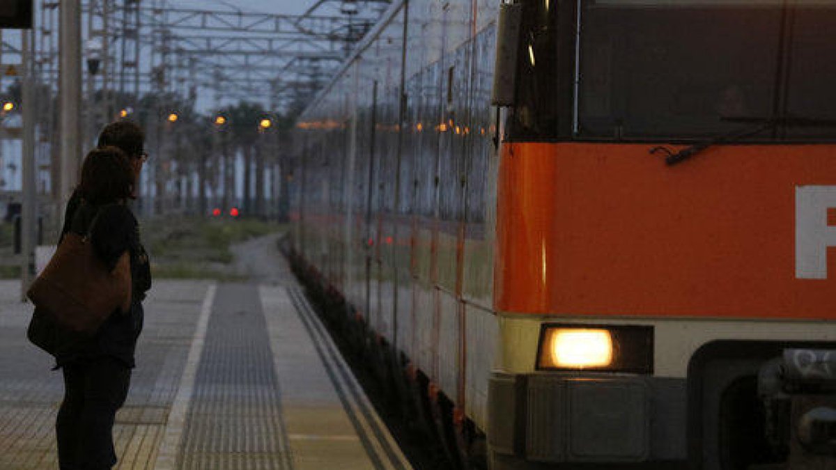 Dos passatgers esperen el tren a l'estació de Mataró, durant la jornada d'aturada general a Catalunya.