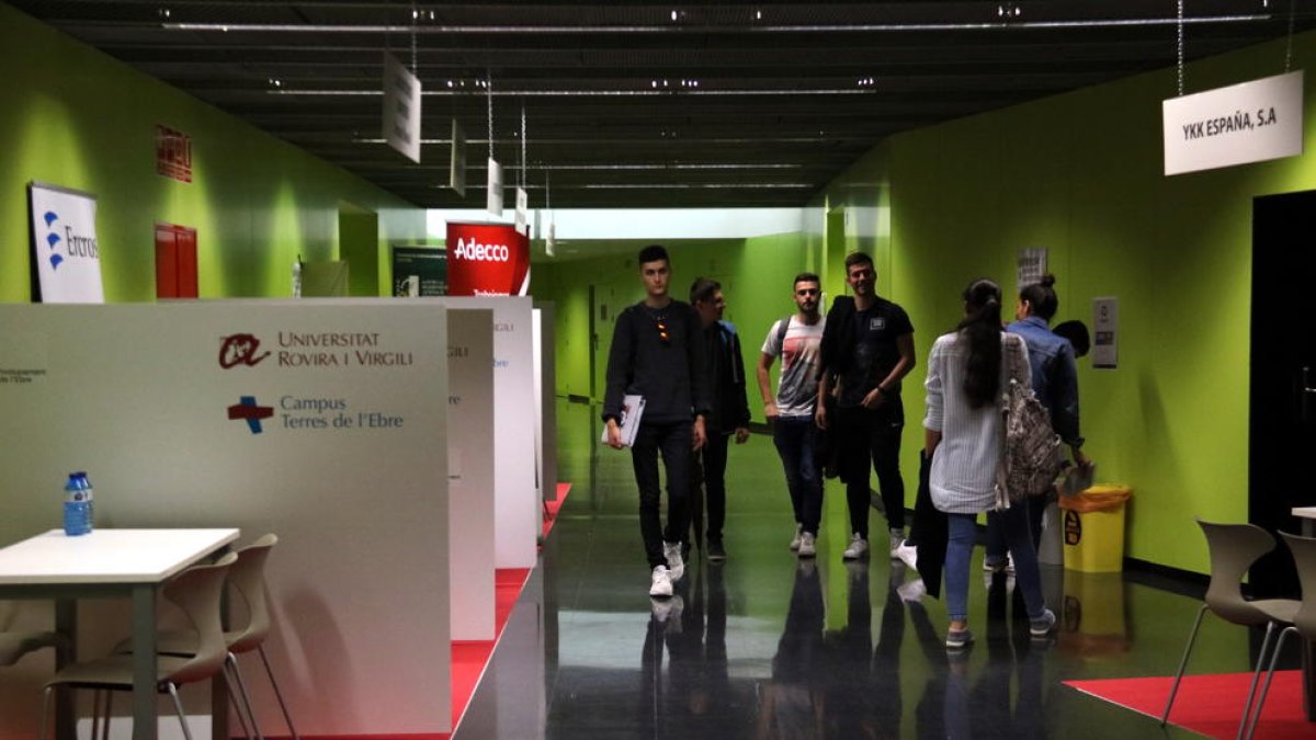 Un grupo de estudiantes paseando entre los stands del Fòrum d'Ocupació i Talent del Campus Terres de l'Ebre de la URV.