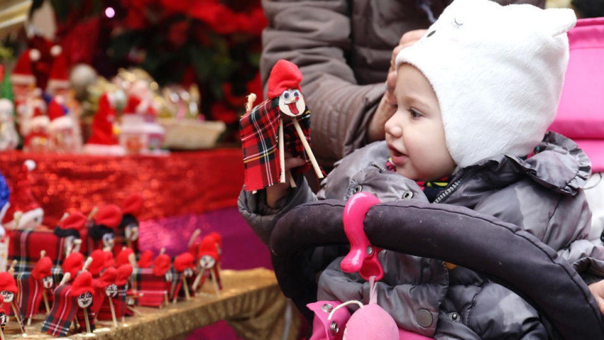 Una niña visitando uno de los mercados de Navidad.