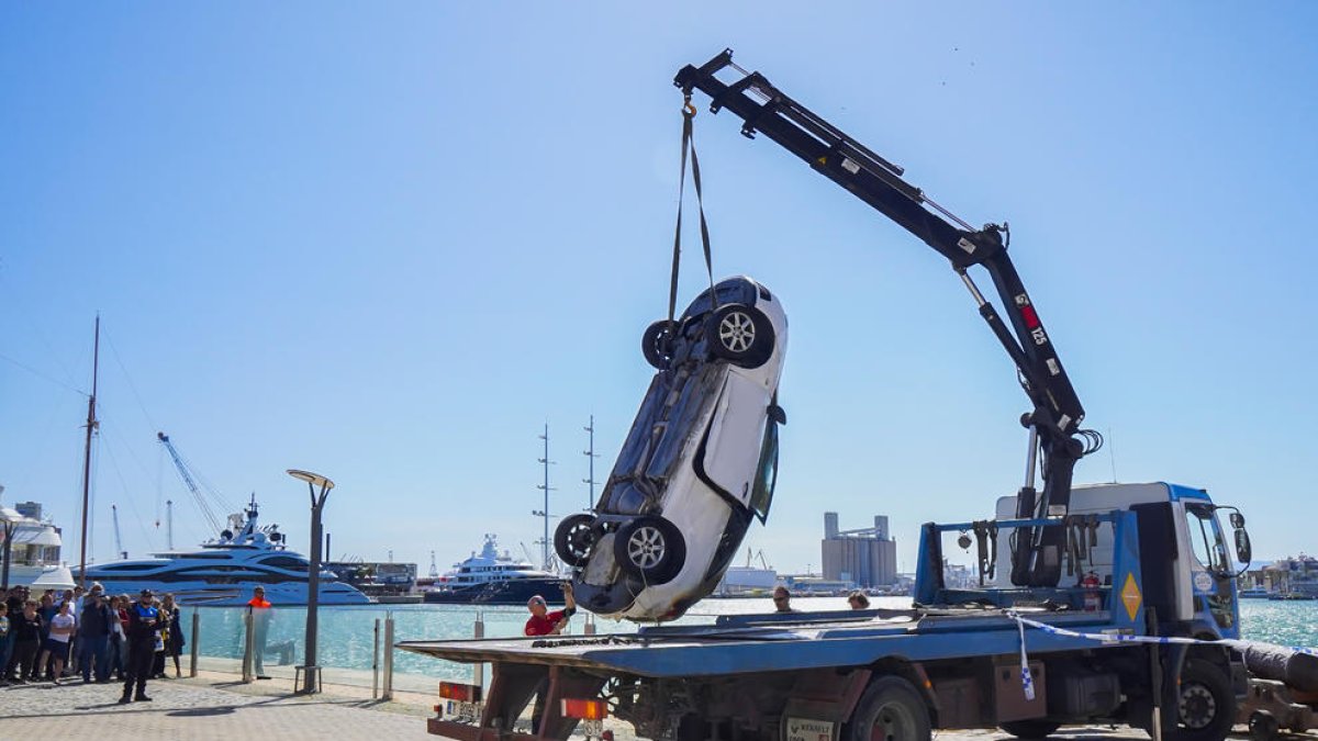 El vehicle és carregat en una grua després de ser tret del mar.