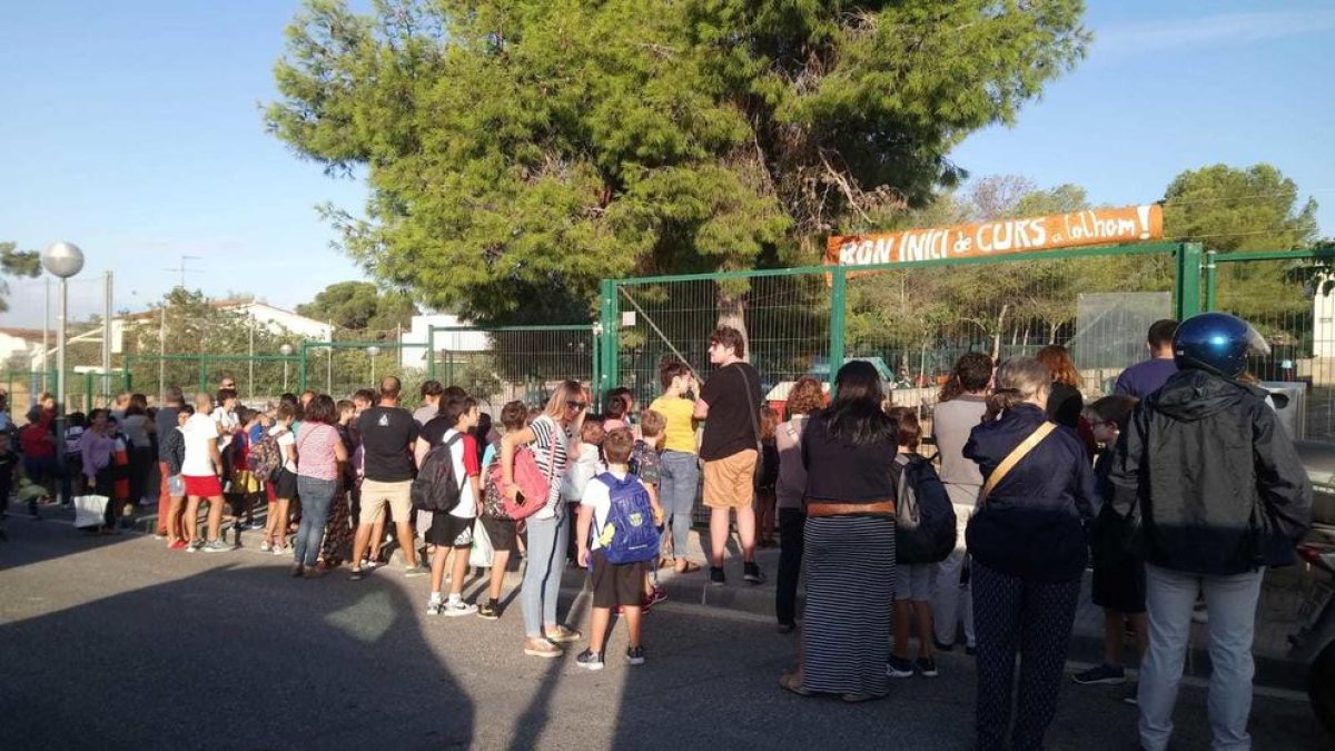 Imagen de varios alumnos y sus padres delante de la Escola l'Arrabassada el primer día del curso 2019-202.