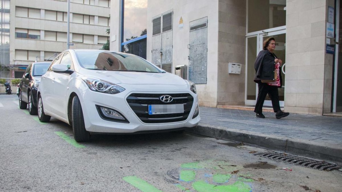 Dos cotxes aparcats ahir a la zona verda al centre de la ciutat.