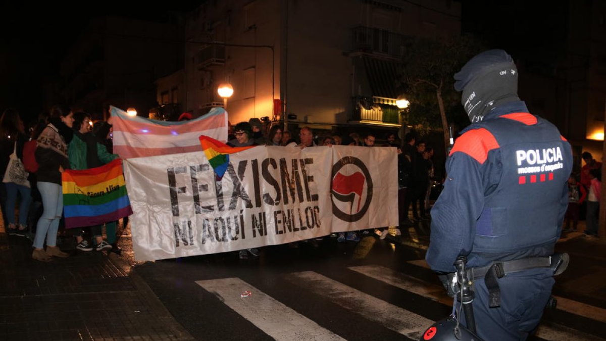 Un Mosso d'Esquadra i els manifestants antifeixistes amb una pancarta durant la protesta en contra la jornada formativa de VOX a Tarragona.