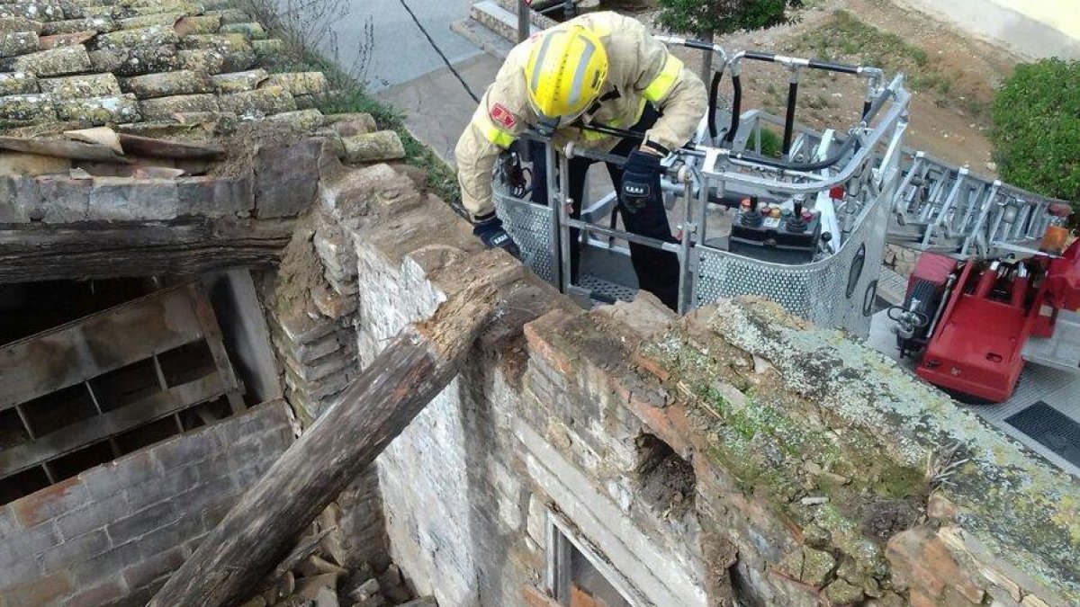 Els bombers treballant en el sanejament de la casa