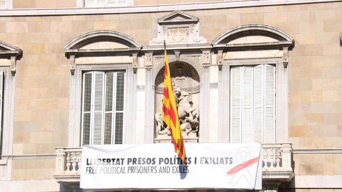 «Llibertat presos polítics i exiliats», diu la nova pancarta amb un llaç blanc amb una franja vermella, en comptes del llaç groc de la pancarta anterior.