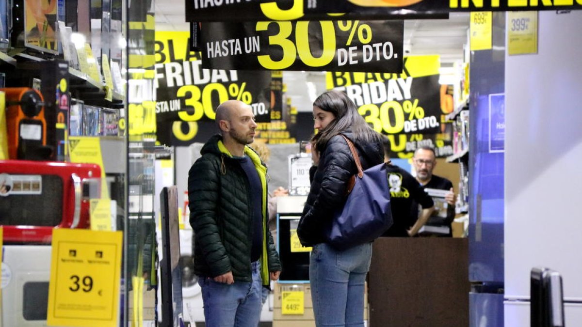 Una pareja en una tienda de electrodomésticos el 'Black Friday'.