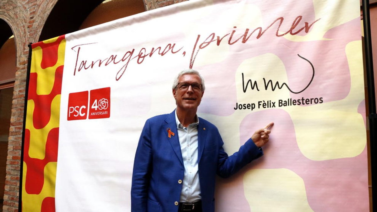 Josep Fèlix Ballesteros, delante del cartel con que ha anunciado que volverá a ser candidato por el PSC en las municipales.