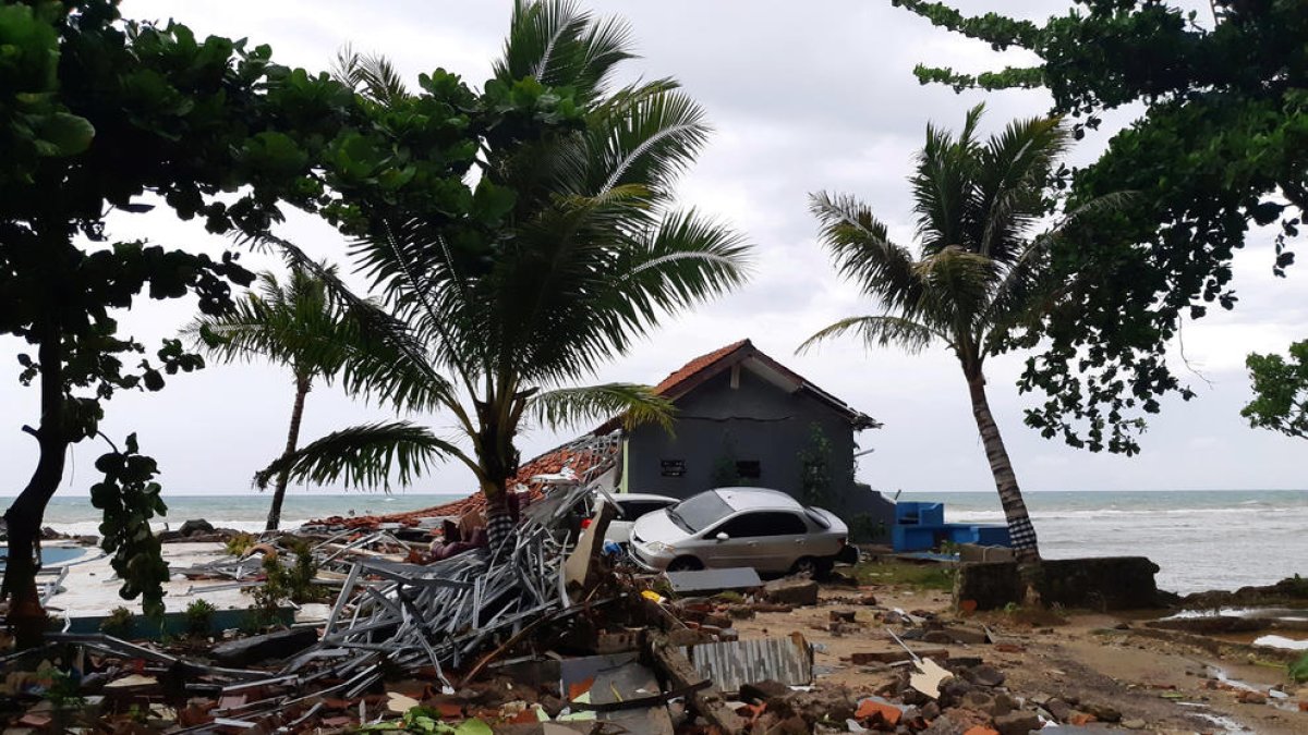 Pilas de escombros y un coche amontonados en la playa de Carita, en Pandeglang.