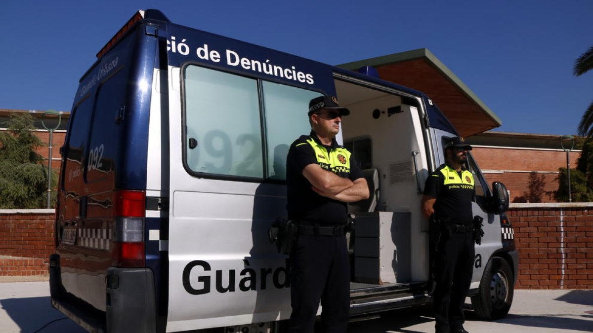 Plan|Plano abierto de dos agentes de la Guardia Urbana de Tarragona al lado de una oficina móvil de denuncias, ante el centro cívico de Torreforta. Imagen del 23 de octubre del 2018