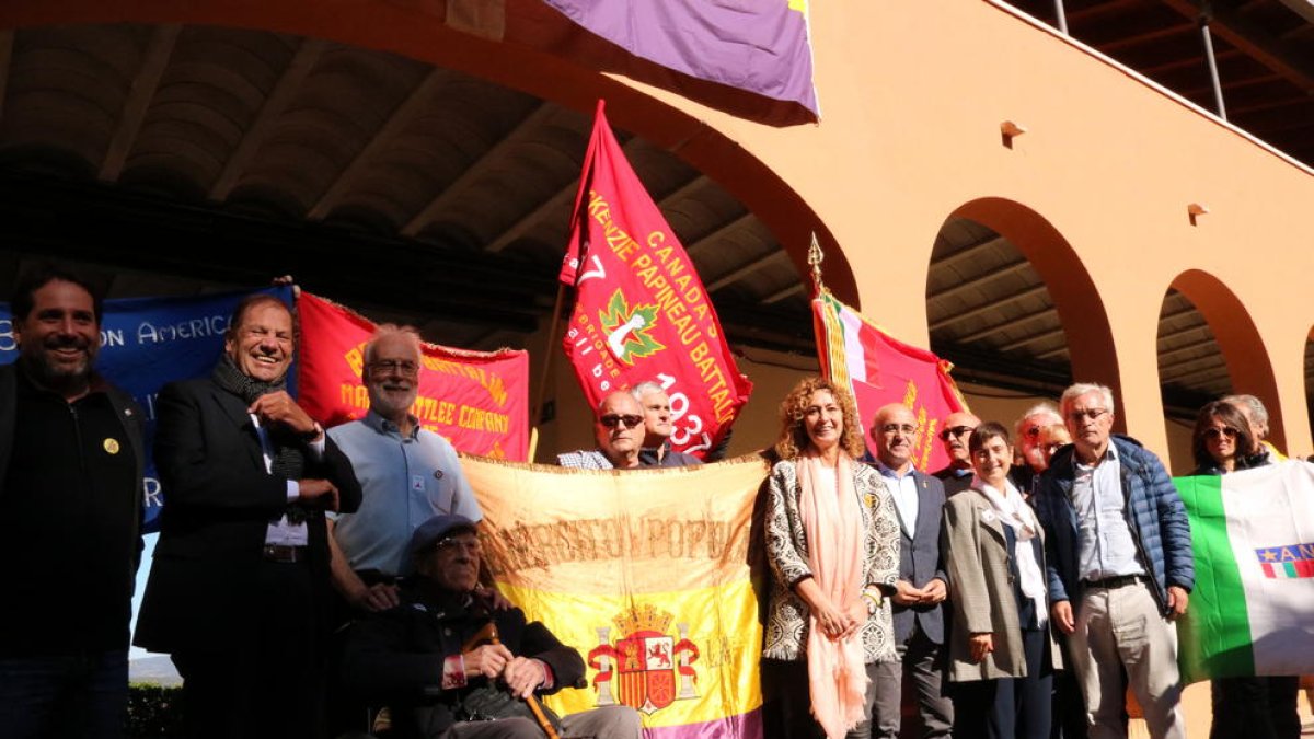 Foto de família de l'acte commemoratiu dels 80 anys del comiat de les Brigades Internacionals a l'Espluga de Francolí amb la consellera Ester Capella en una composició que busca reproduir una foto de l'època.