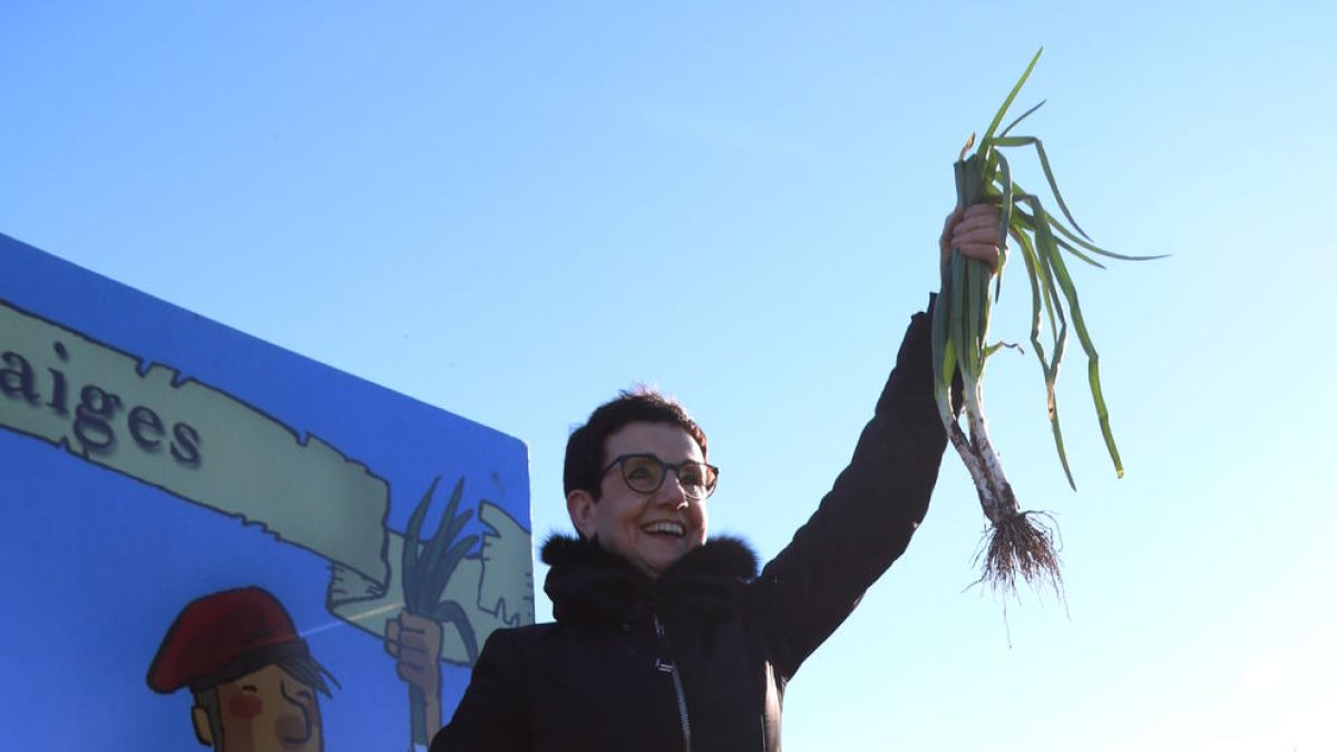 Carme Ruscadella alzando un calçot en el arranque simbólico de la primera cebolla dulce de la temporada en la 5ª Jornada Gastronómica de Valls.