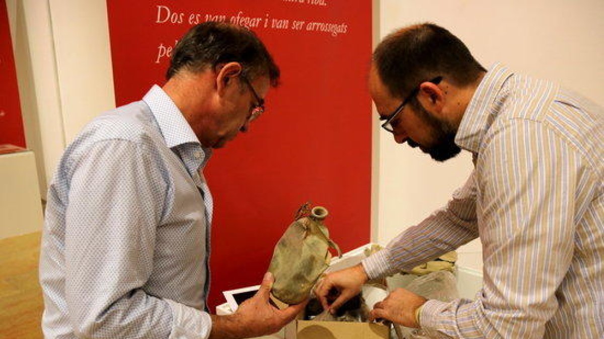 El director del Museu de les Terres de l'Ebre, Àlex Farnós, y el coordinador técnico del Comebe, David Tormo, revisan objetos de la guerra civil que se expondrán en la muestra de los brigadistas inernacionales.