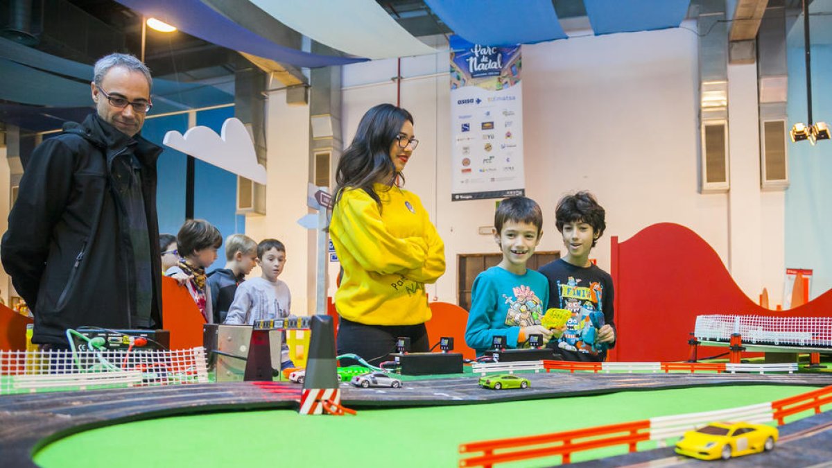 Dos niños frente la pista gigante de Scalextric.