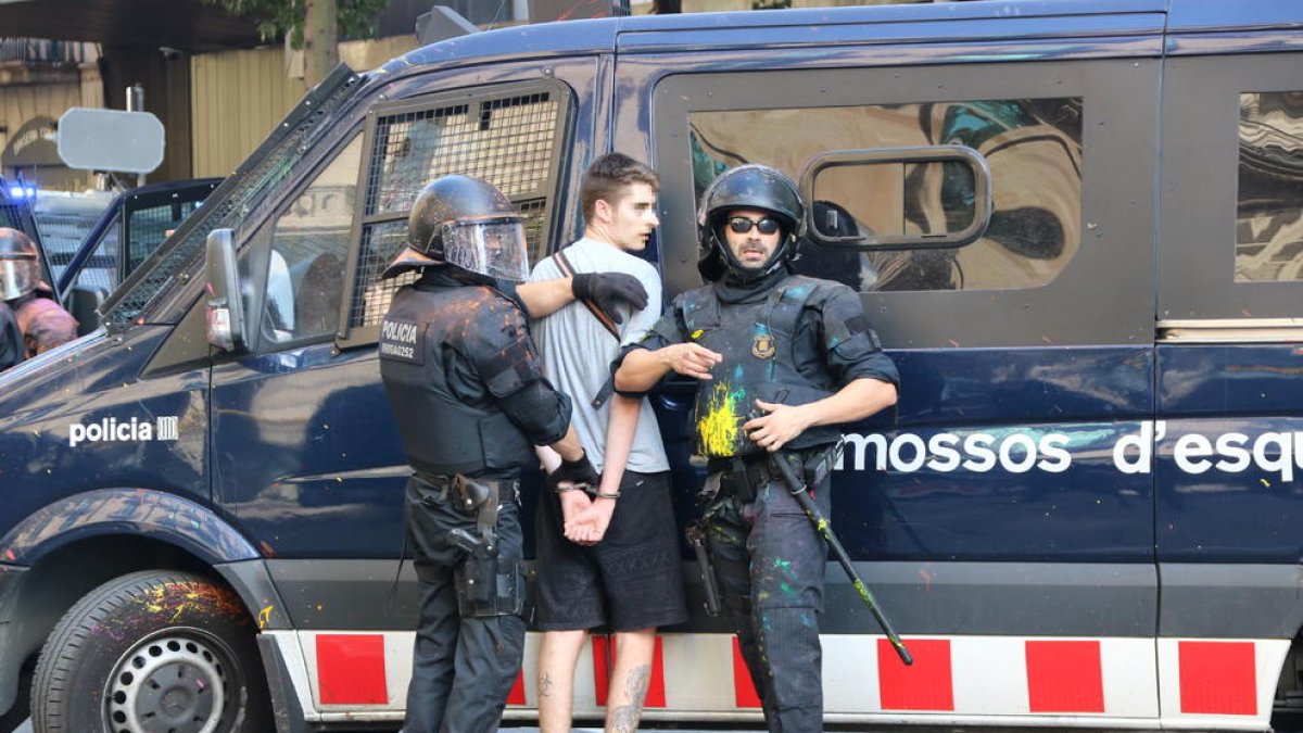Imatge d'un jove detingut per part d'un grup de Mossos d'Esquadra.
