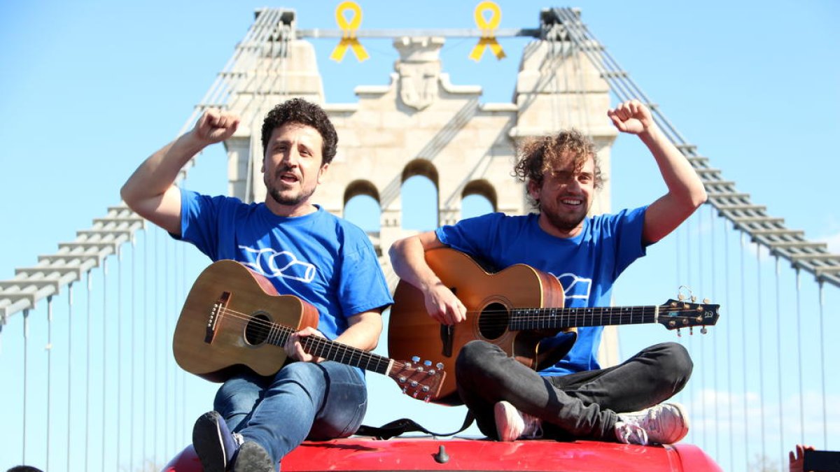 Plan|Plano abierto del cantante de Pepet i Marieta, Josep Bordes, y de un miembro del grupo encima de un vehículo durante el rodaje del videoclip 'La fuerza del Ebro', en el Puente de Amposta. Imagen del 2 de marzo del 2019 (Horizontal).