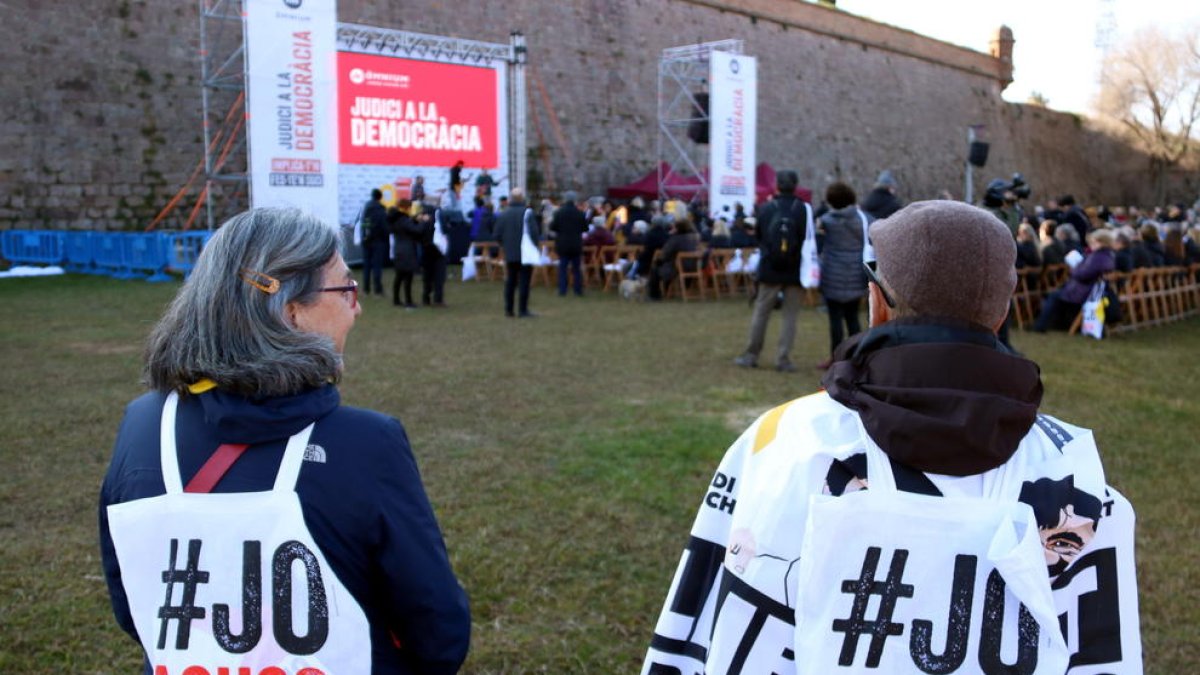Dos simpatitzants d'Òmnium amb motxilles de la campanya 'Judici a la democràcia', presentada al Castell de Montjuïc.