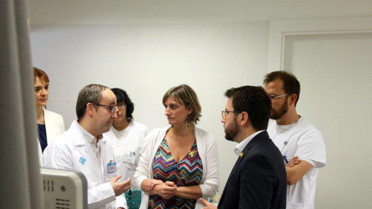 El vicepresidente del Govern, Pere Aragonès, y la consellera de Salut, Alba Vergés, hablando con personal médico dentro de una consulta del CUAP Sant Martí de Barcelona.