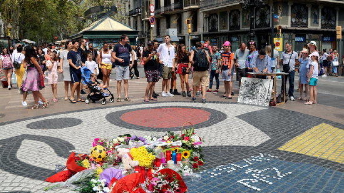 El mosaic de Miró a la Rambla amb flors i espelmes en honor a les víctimes de l'atemptat del 17-A.