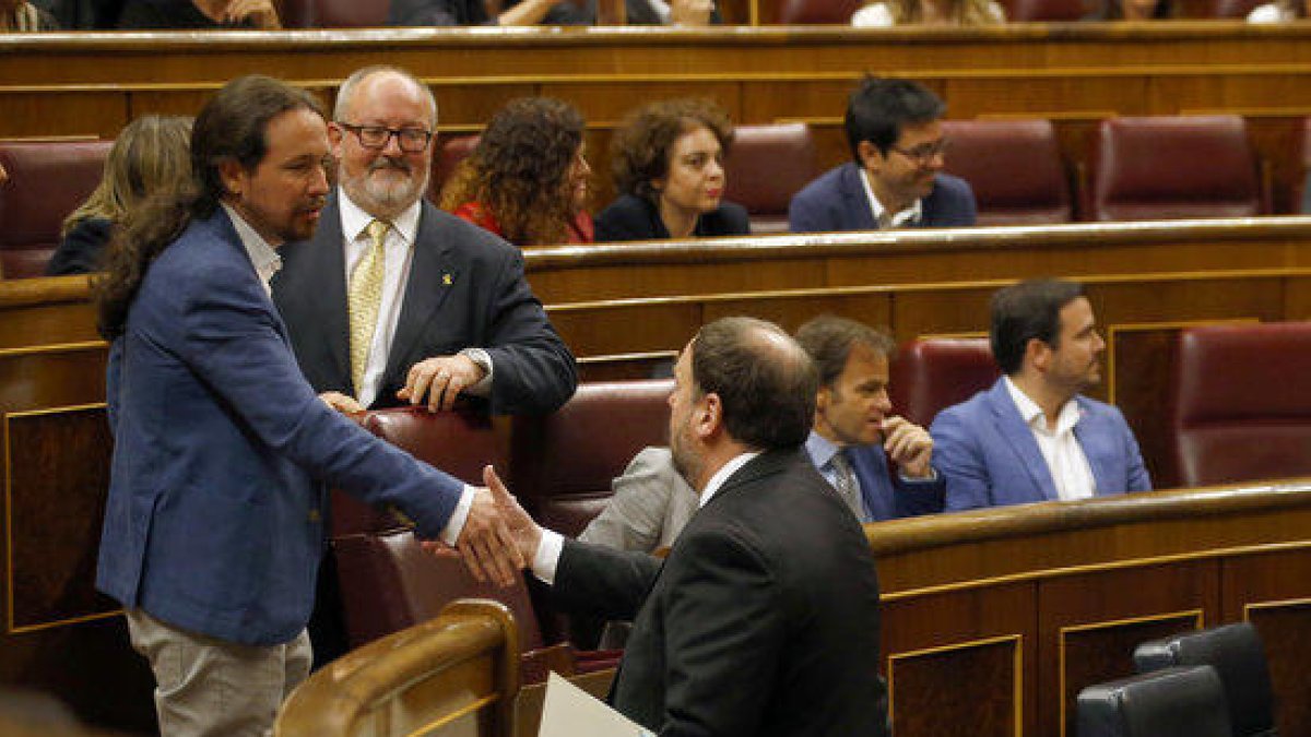 El líder de Podemos, Pablo Iglesias, saluda al presidente de ERC, Oriol Junqueras, durante la sesión de constitución del Congreso de los Diputados.