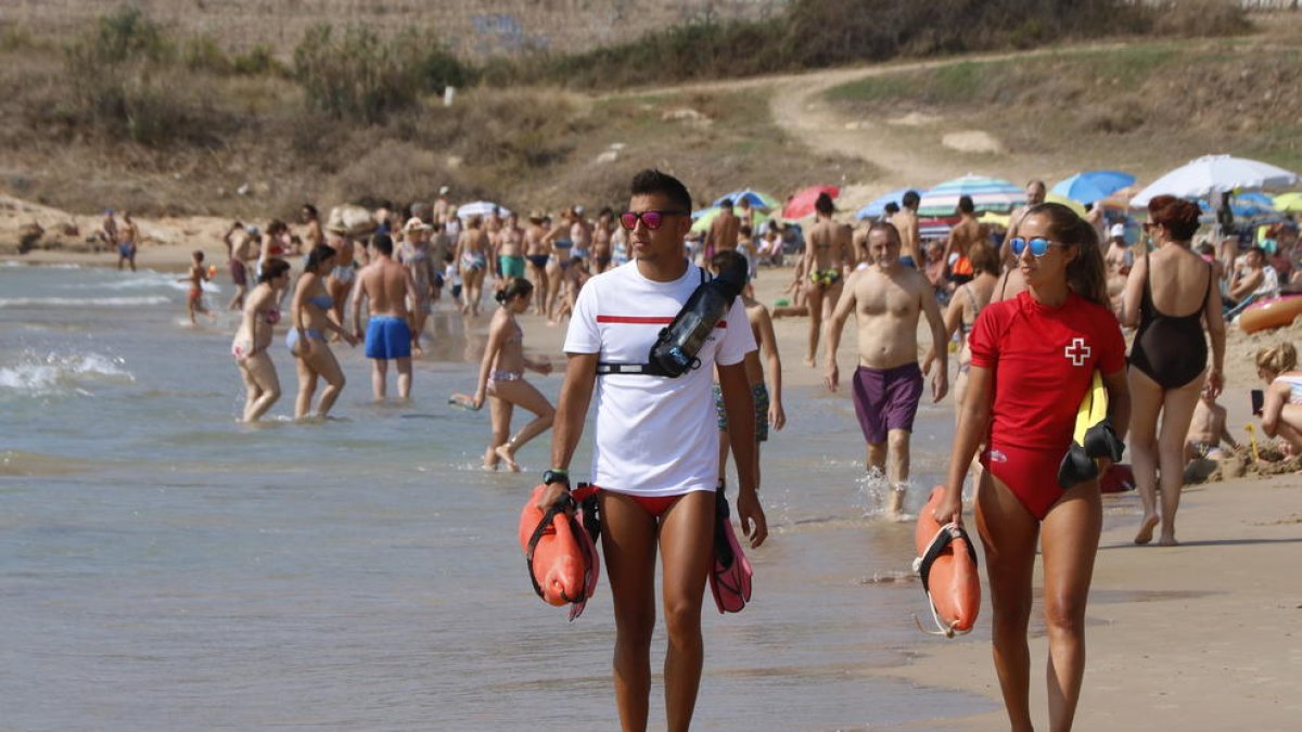 Dos socorristas de la Cruz Roja patrullando por la playa de l'Arrabassada de Tarragona durante este agosto.