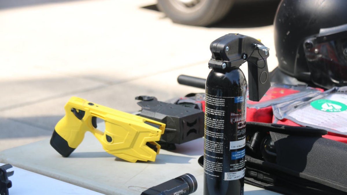 Un arma de electrochoque o pistola tàser y un dispensador de gas pimienta, dos elementos que forman parte del equipamiento de la Brigada Móvil de los Mossos d'Esquadra.