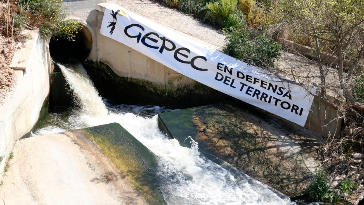 Imagen de la salida de las aguas de la depuradora de Reus, con un cartel de Gepec para denunciar que este caudal no se reutilice y se siga trasvasando agua del río Siurana en el pantano de Riudecanyes.