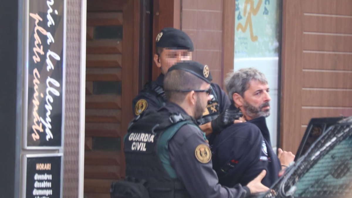 Dos agentes de la Guardia Civil se llevan a un detenido a Sabadell.