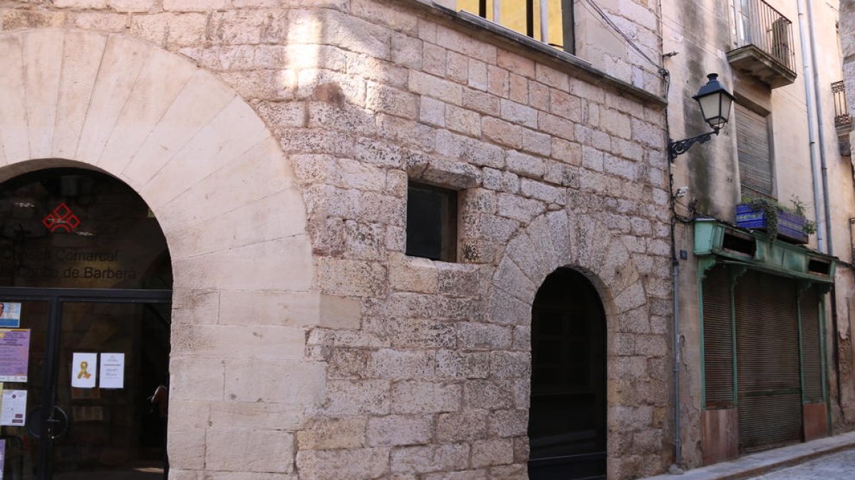 Entrada al Consell Comarcal de la Conca de Barberà, a Montblanc, i al fons, una antiga botiga de queviures i una casa de grans dimensions annexa, propietat de l'ens amb la intenció d'ampliar la seu.