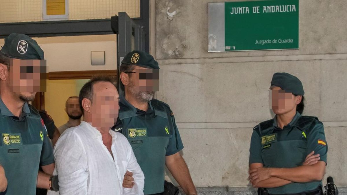 El gerente de Magrudis, José Antonio Marín, y su hijo Sandro (detrás), son trasladados a los calabozos después de declarar.