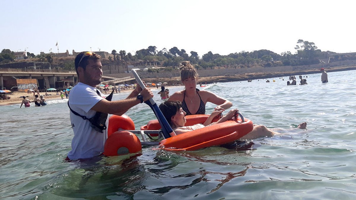 Una de las usuarias en una silla anfibia en la playa del Milagro.