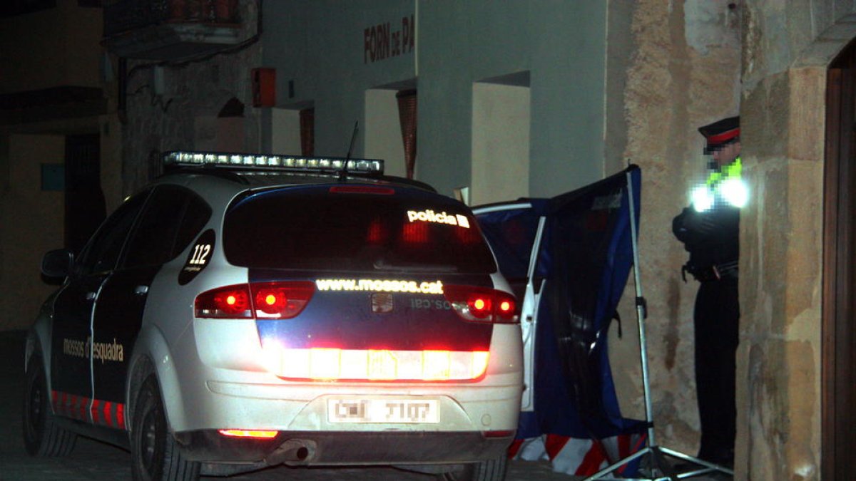 Un vehicle dels Mosso d'Esquadra i un agent custodiant l'entrada a la casa on s'ha produït l'incendi mortal a Arnes.